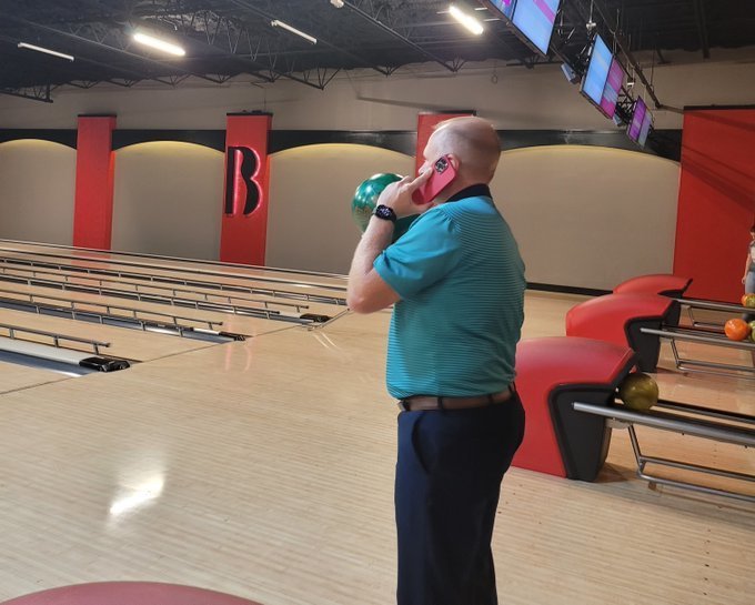 Dr. Ford bowling and talking on the phone.